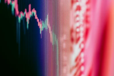 Personne calculant un budget mensuel avec une calculatrice et des documents financiers sur un bureau